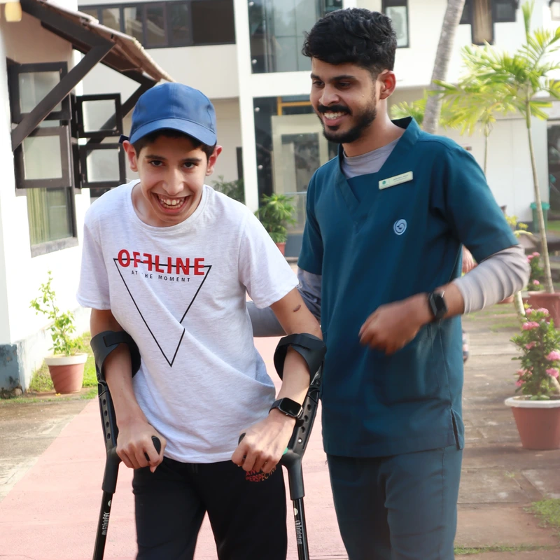 Patient walking on crutches with physiotherapist during neurological recovery